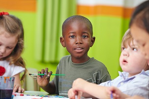 3 young boys playing a game at a desk