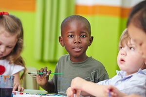 3 young boys playing a game at a desk