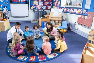 Young children on a mat talking with adult