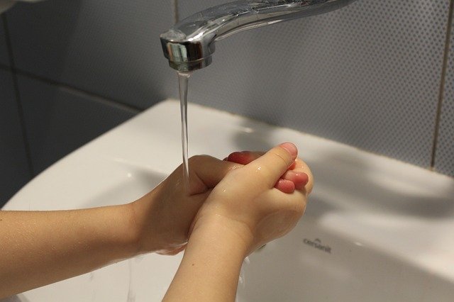 Child hands washing under a running tap