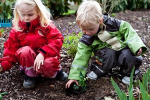 Children with their rain gear on playing in the mud