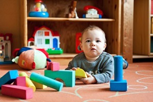 Baby boy lying on his tummy surrounded by toy bricks