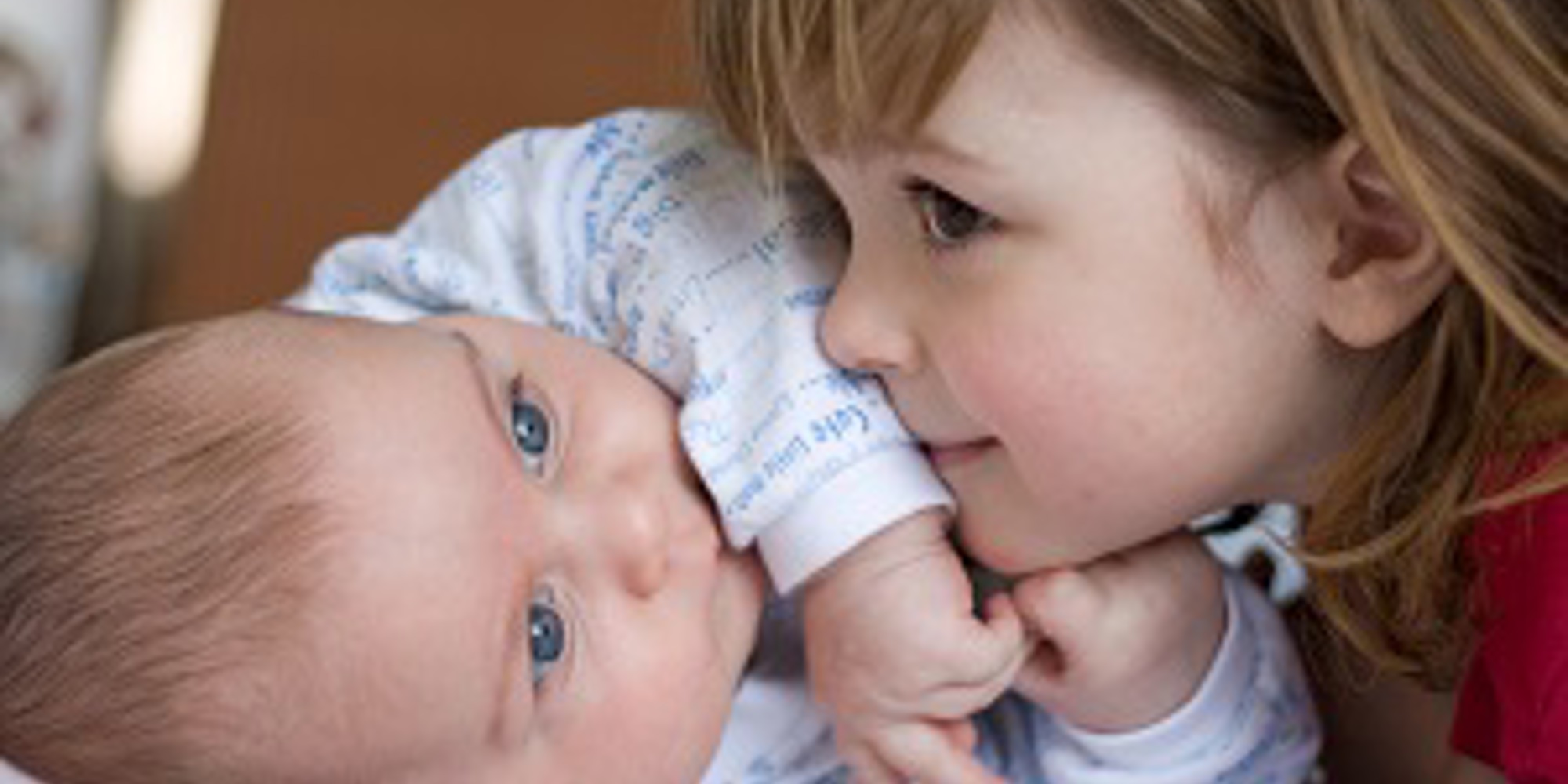 Young girl lying close to baby boy