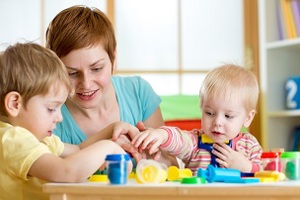 Adult woman playing with a young children