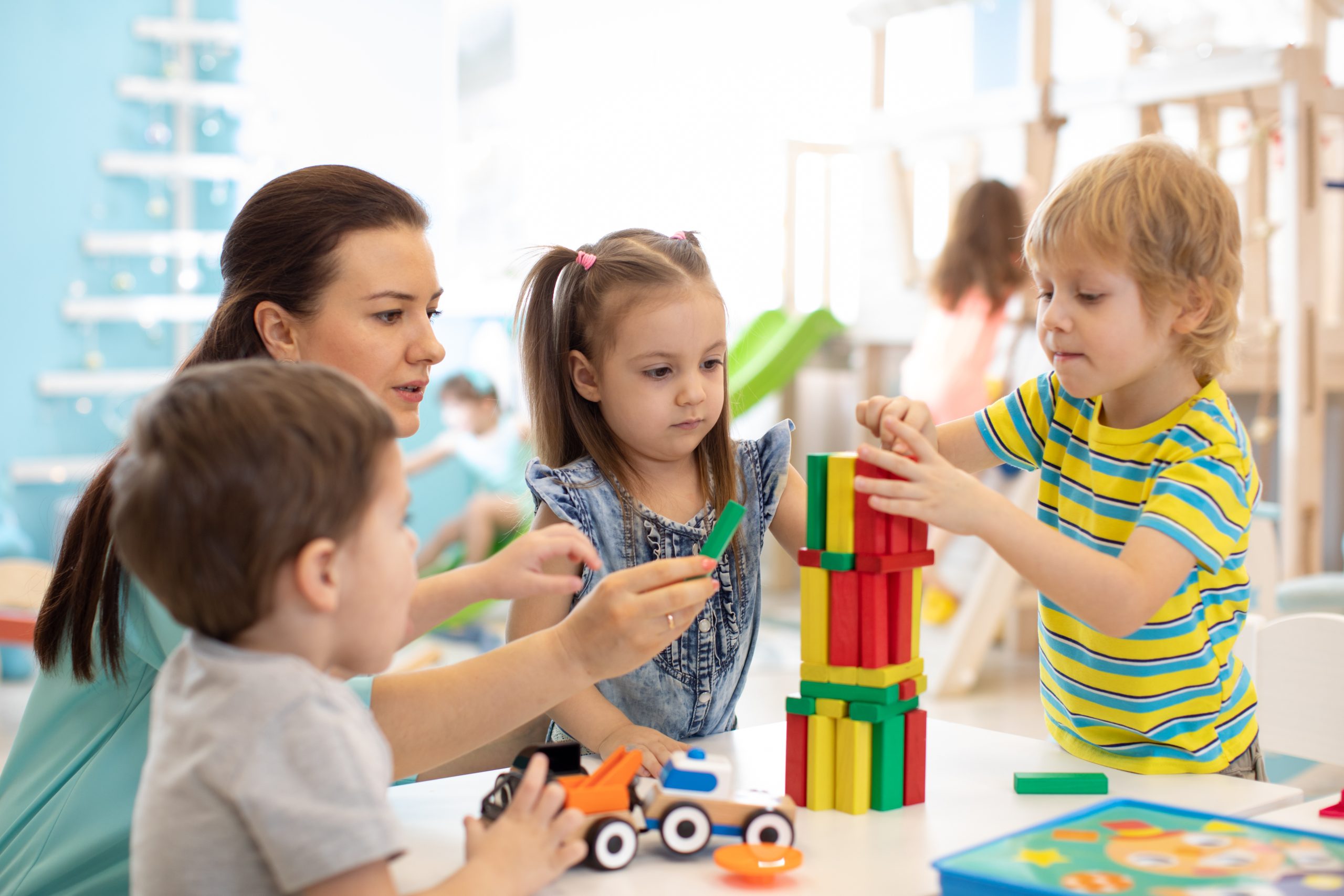 Pre school children bilding a tower with wooden blocks