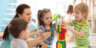 Pre school children bilding a tower with wooden blocks