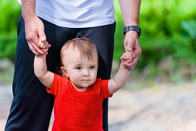 Adult helping child to walk