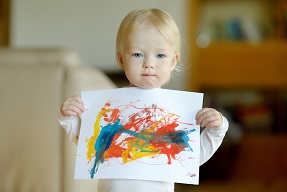 Little girl showing her finished painting