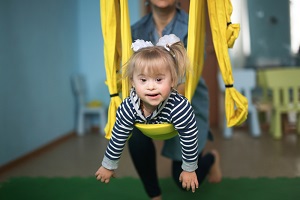 Young Down's girl in a sensory swing