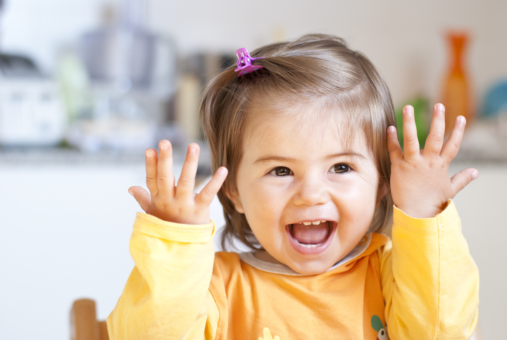 Young girl smiling in yellow painting apron