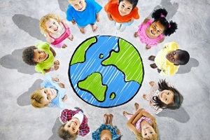 Children standing in a circle around an image of Earth