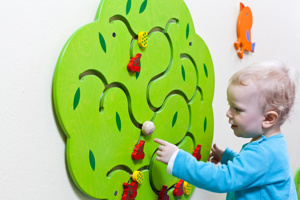 Little boy playing with a wall puzzle