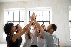 Group of adults clapping their hands up together