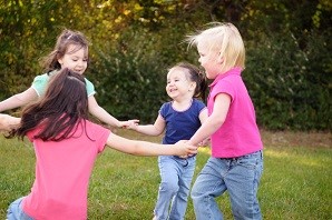 4 young girls holding hands in a circle