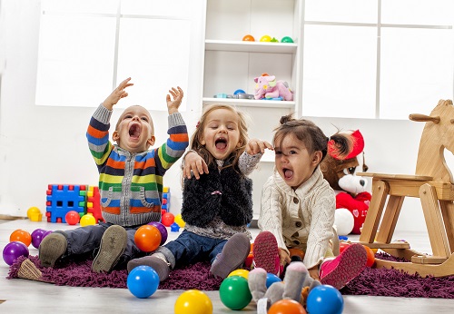 3 happy young children in a nursery setting