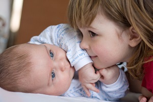 Young girl with small baby boy