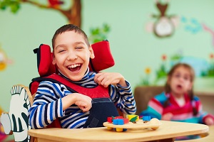 Young smiling boy with disabilities in a nursery setting
