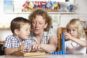 Adult playing learning games with a young boy and girl