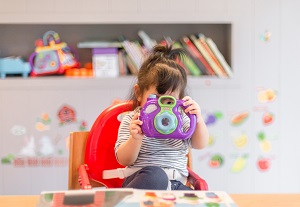 Toddler hands playing with coloured bricks of different shapes