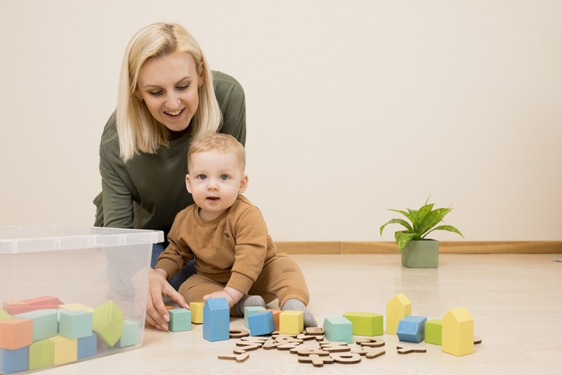 Woman with baby boy playing with coloured bricks