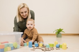 Woman with baby boy playing with coloured bricks